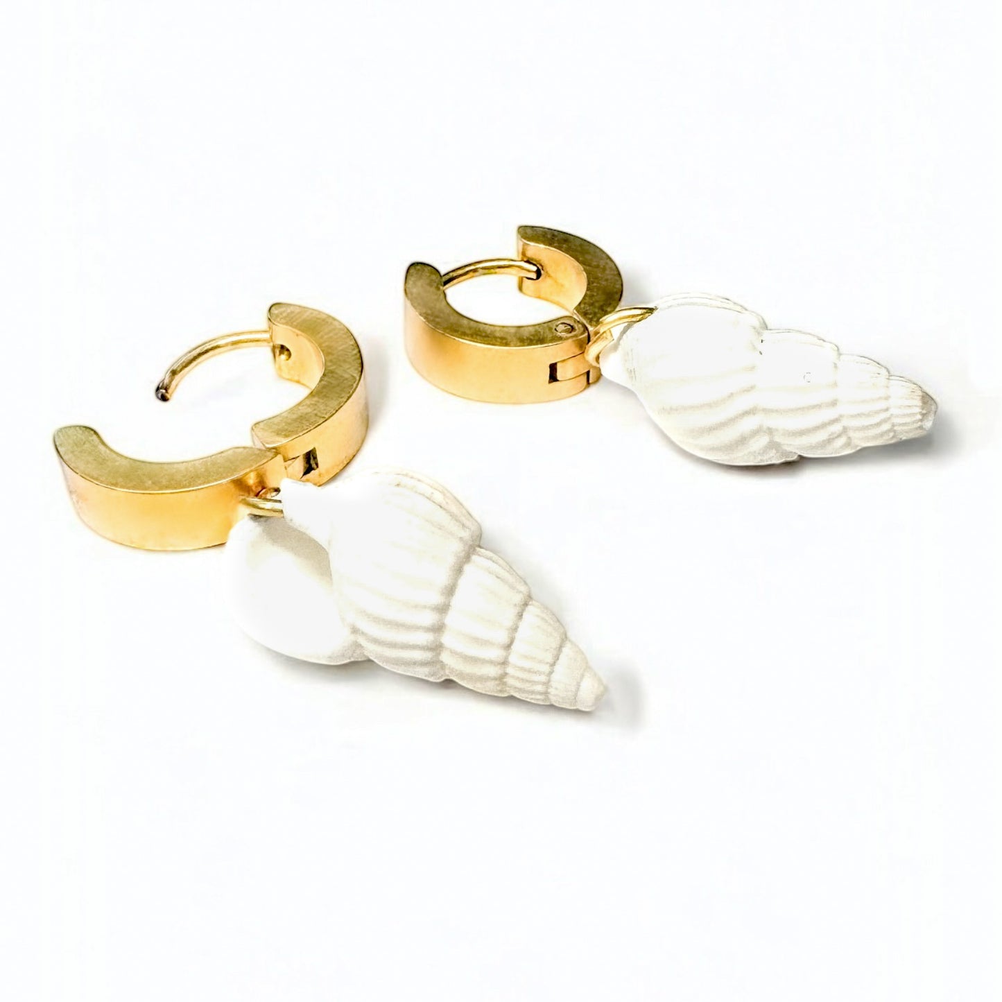 Pair of gold hoop earrings with white shell designs on a white background
