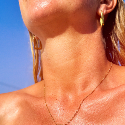 Close-up of a person's neck and shoulders with a blue sky background